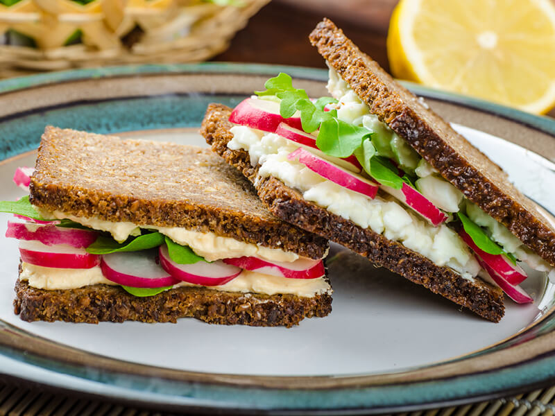 Sandwich healthy à l'œuf et aux radis pour illustrer un article de blog sur les astuces anti-grignotage