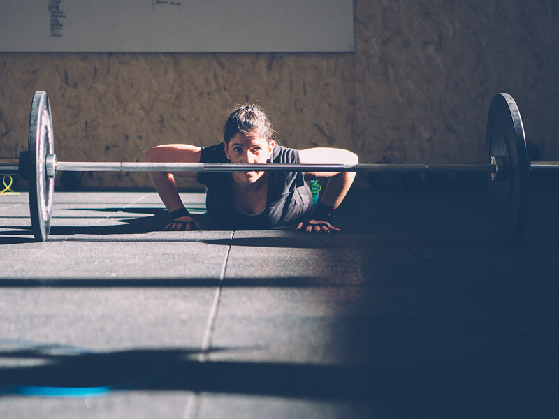 Femme en train de faire des burpees lors d'une séance d'entrainement