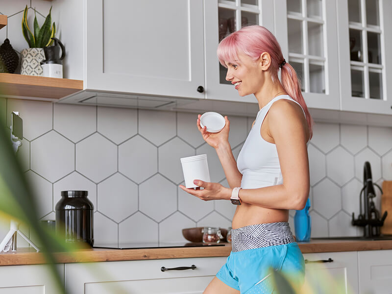 Une jeune femme en tenue de sport dans sa cuisine