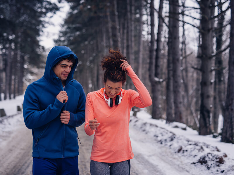 Un couple en train de pratiquer du sport en extérieur en hiver
