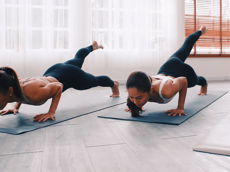 Deux jeunes femmes pratiquant le Pilates dans une salle de cours