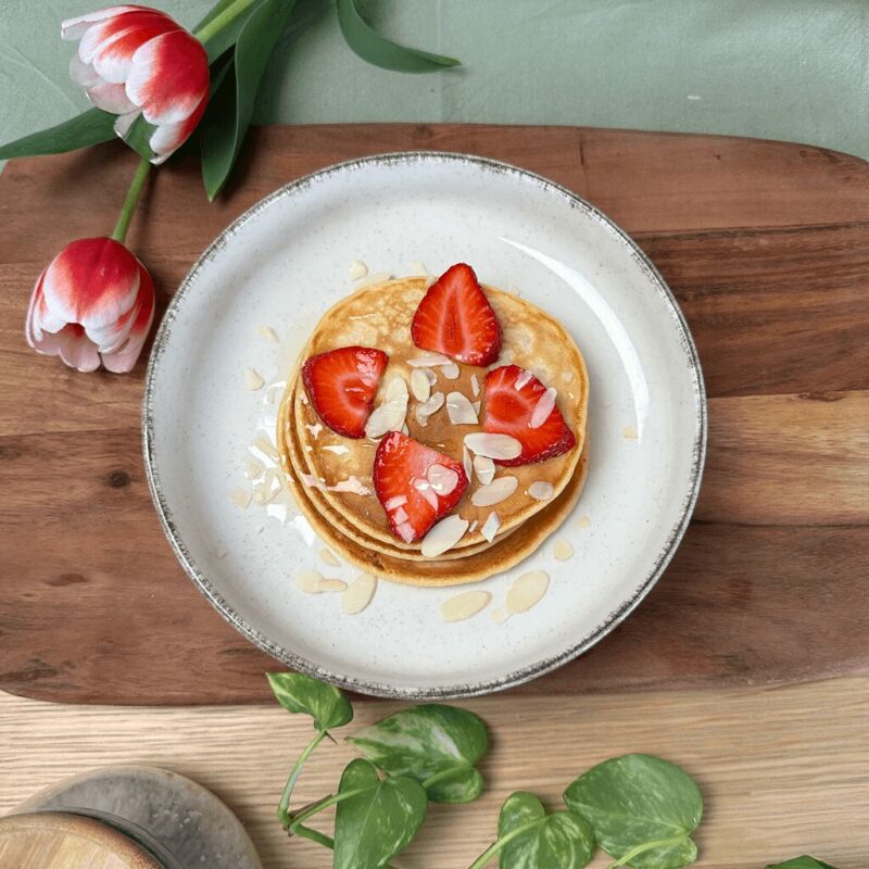 Pancakes sains garnis de fraises fraîches, parfaits pour un petit-déjeuner équilibré.