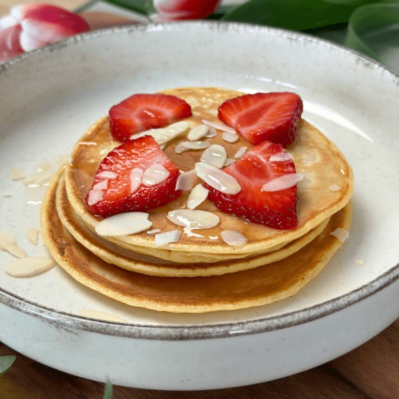 Pancakes sains garnis de fraises fraîches, parfaits pour un petit-déjeuner équilibré.