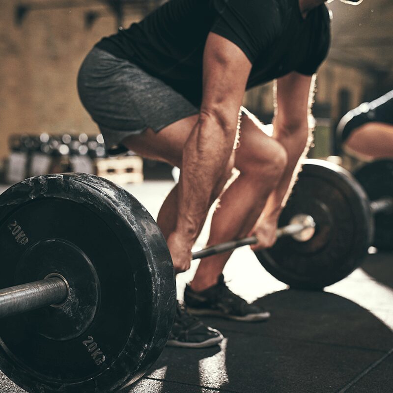 Un homme réalisant un deadlift, un exercice bas du corps essentiel proposé par L'Appart Fitness pour renforcer les ischio-jambiers et fessiers.