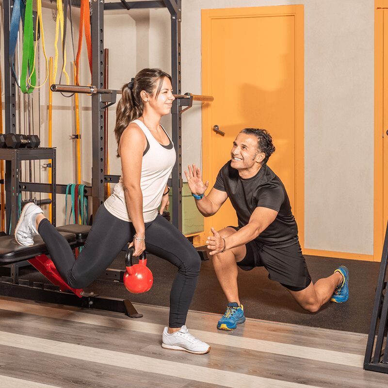Une femme faisant des squats bulgares, un exercice bas du corps dynamique recommandé par L'Appart Fitness