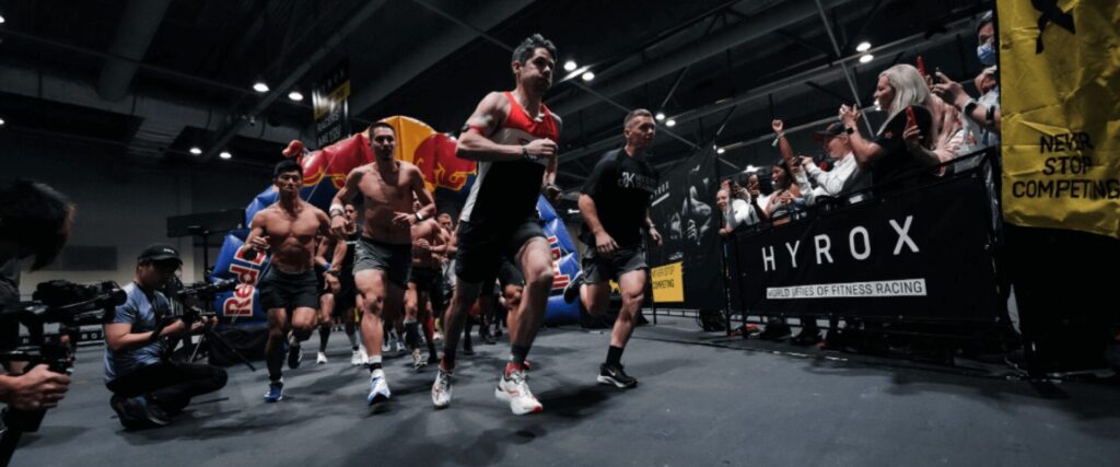 Compétition Hyrox avec des athlètes en pleine course - L'Appart Fitness Villeurbanne propose des cours d'Hyrox pour relever le défi !