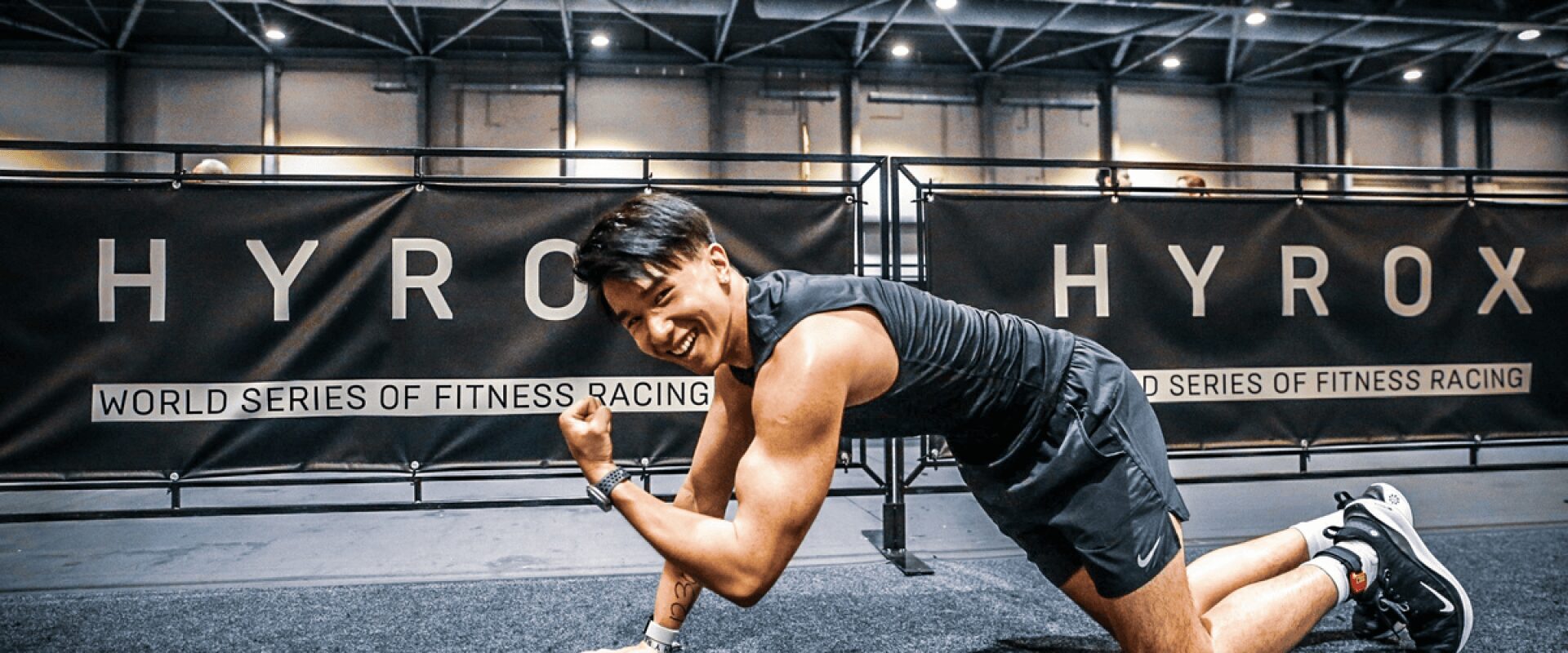 Sportif au sol souriant, après un challenge Hyrox organisé par L'Appart Fitness.