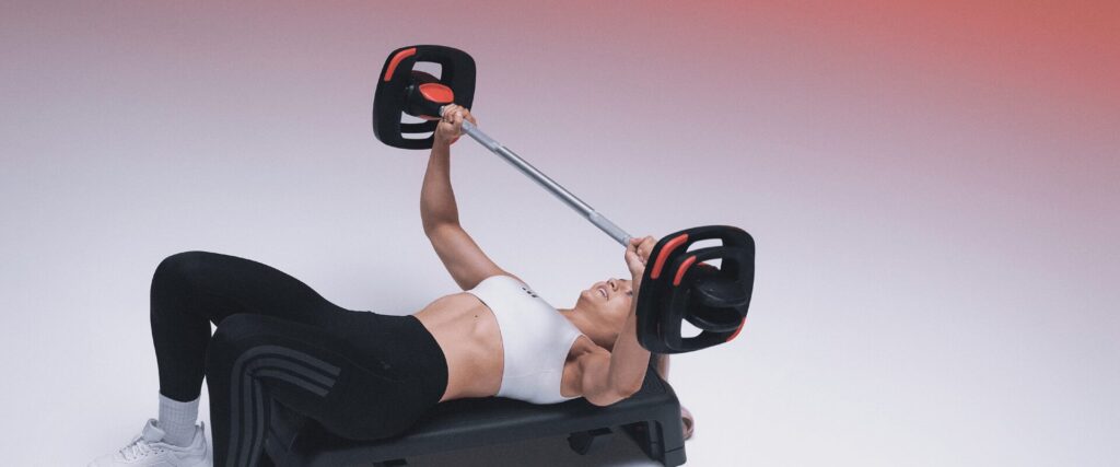 Adhérente réalisant un développé couché dans le cadre d’un programme musculation à L’Appart Fitness, un entraînement complet combinant force et tonification.
