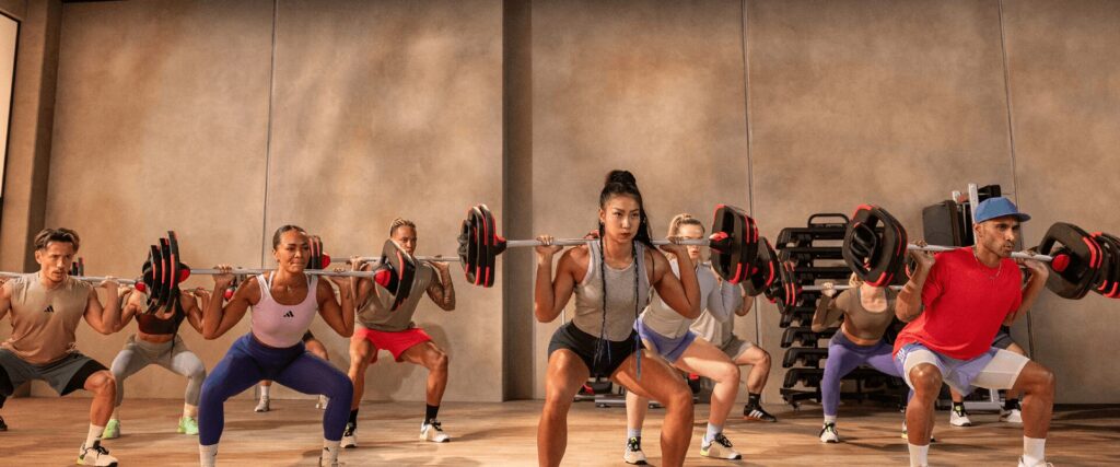 L’Appart Fitness : quel cours collectif choisir ? groupe d’adhérents en séance de Bodypump, renforçant leur musculature avec des charges légères et répétitions élevées.