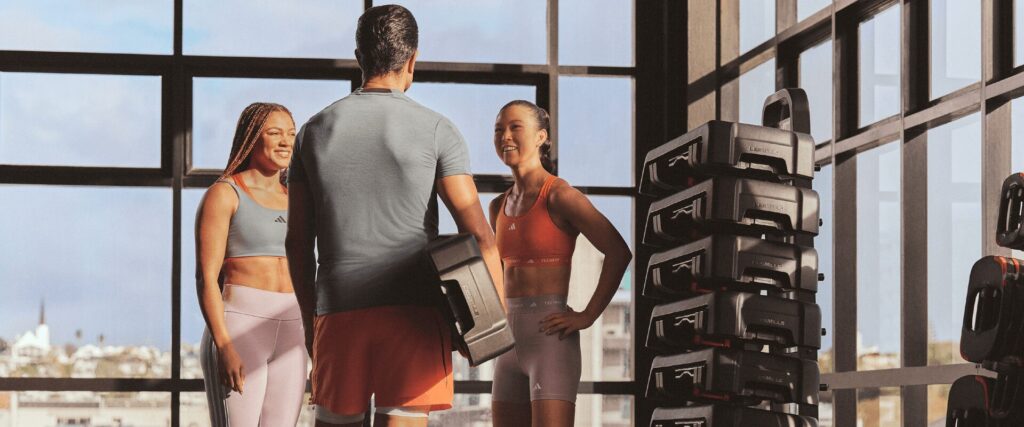 Coach L’Appart Fitness échange avec deux adhérentes avant une séance Small Group.